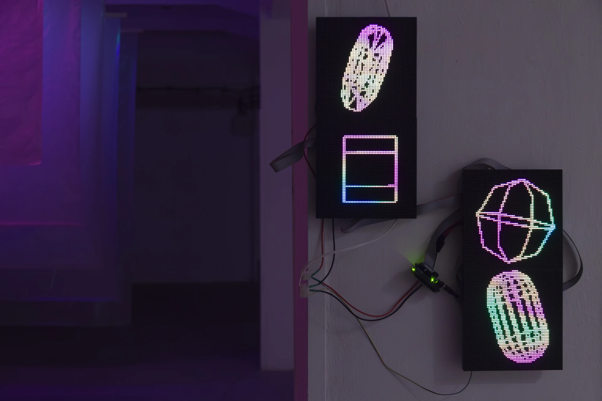 Stacked LED screens displaying coloured wireframe shapes