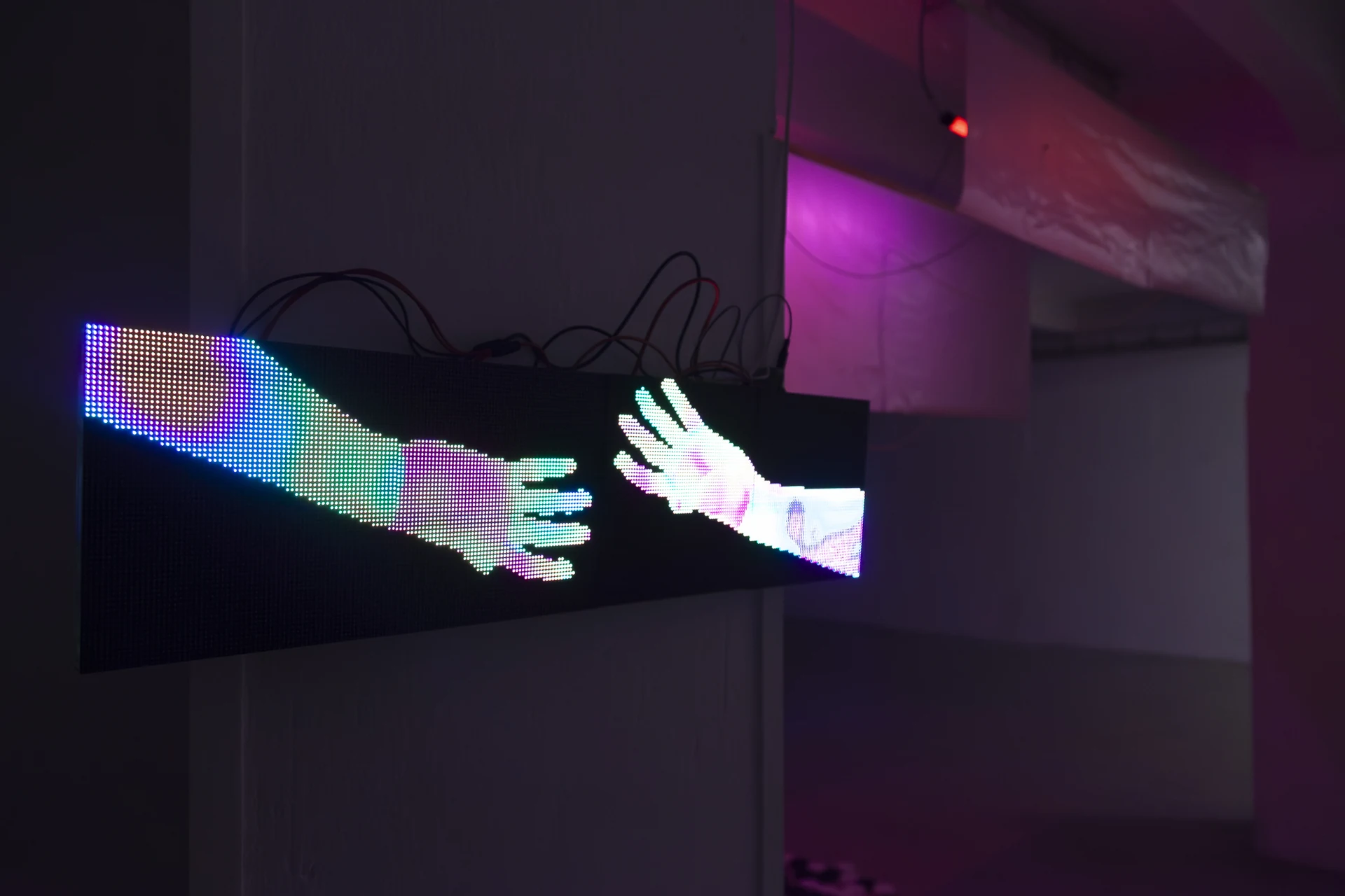 Two pixelated hands reaching towards each other across a screen