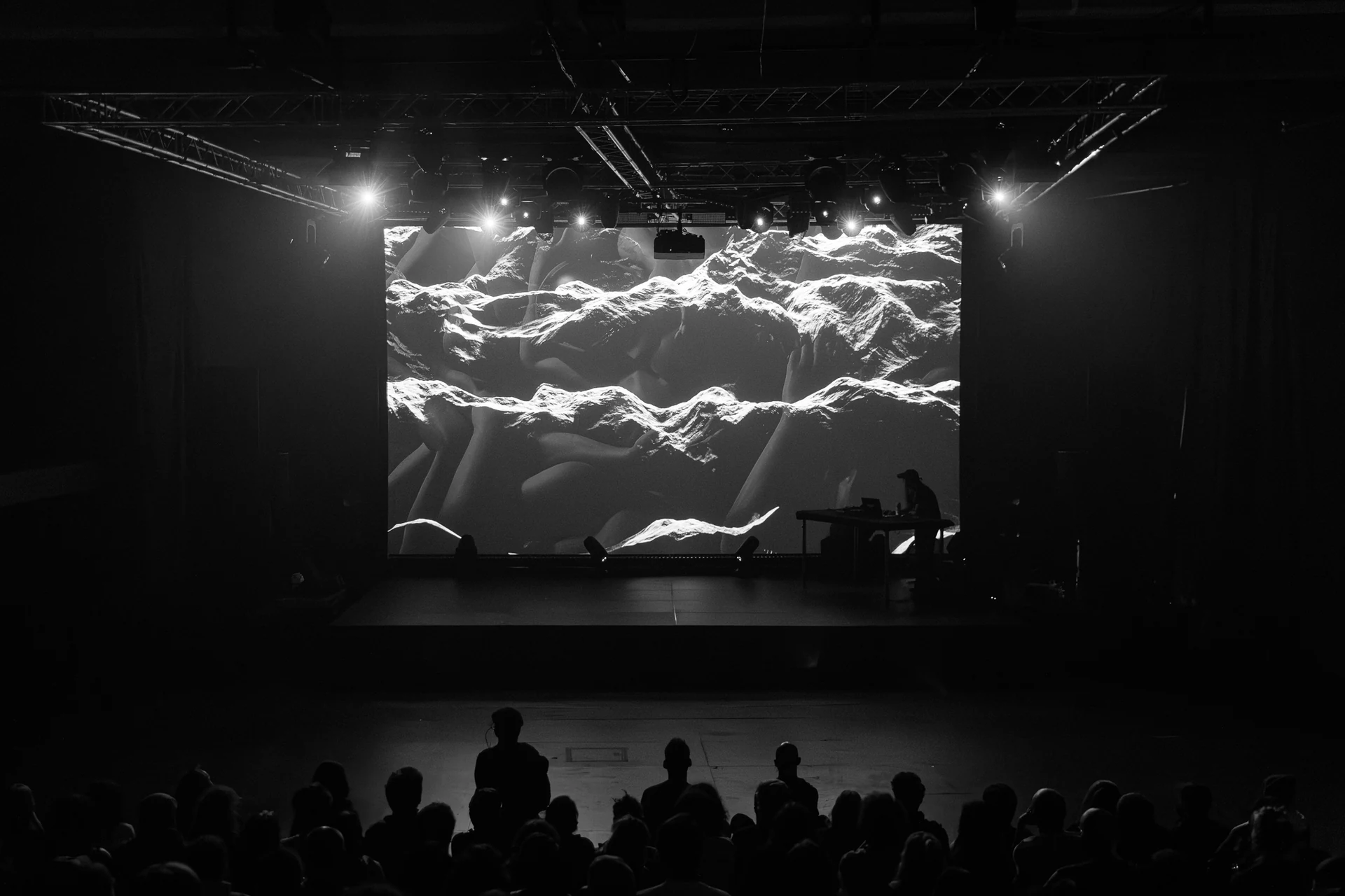 Live audiovisual performance with a monumental projected landscape and an audience in silhouette