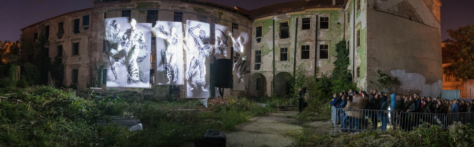 Projection across a building facade with spectators gathered in front